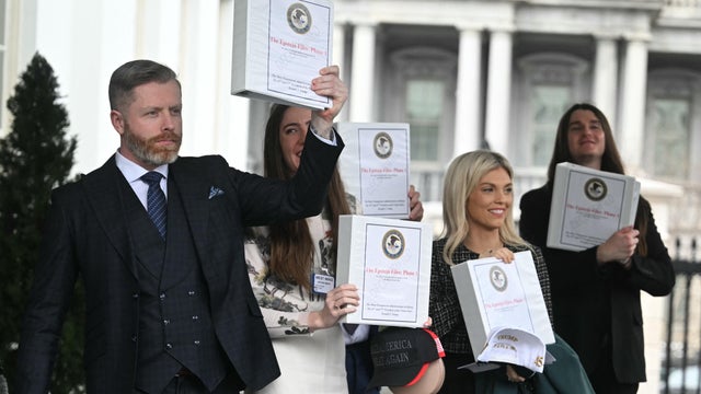From left, Rogan O'Handley, Chaya Raichik, Scott Presler, Liz Wheeler and Chad Prather carry binders labeled "The Epstein Files: Phase 1" as they walk out of the West Wing of the White House on Thursday, Feb. 27, 2025. 